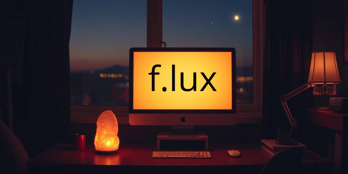 A computer screen displays the f.lux logo, with a warm orange light. A lamp and a salt lamp sit on a desk in a dimly lit room.
