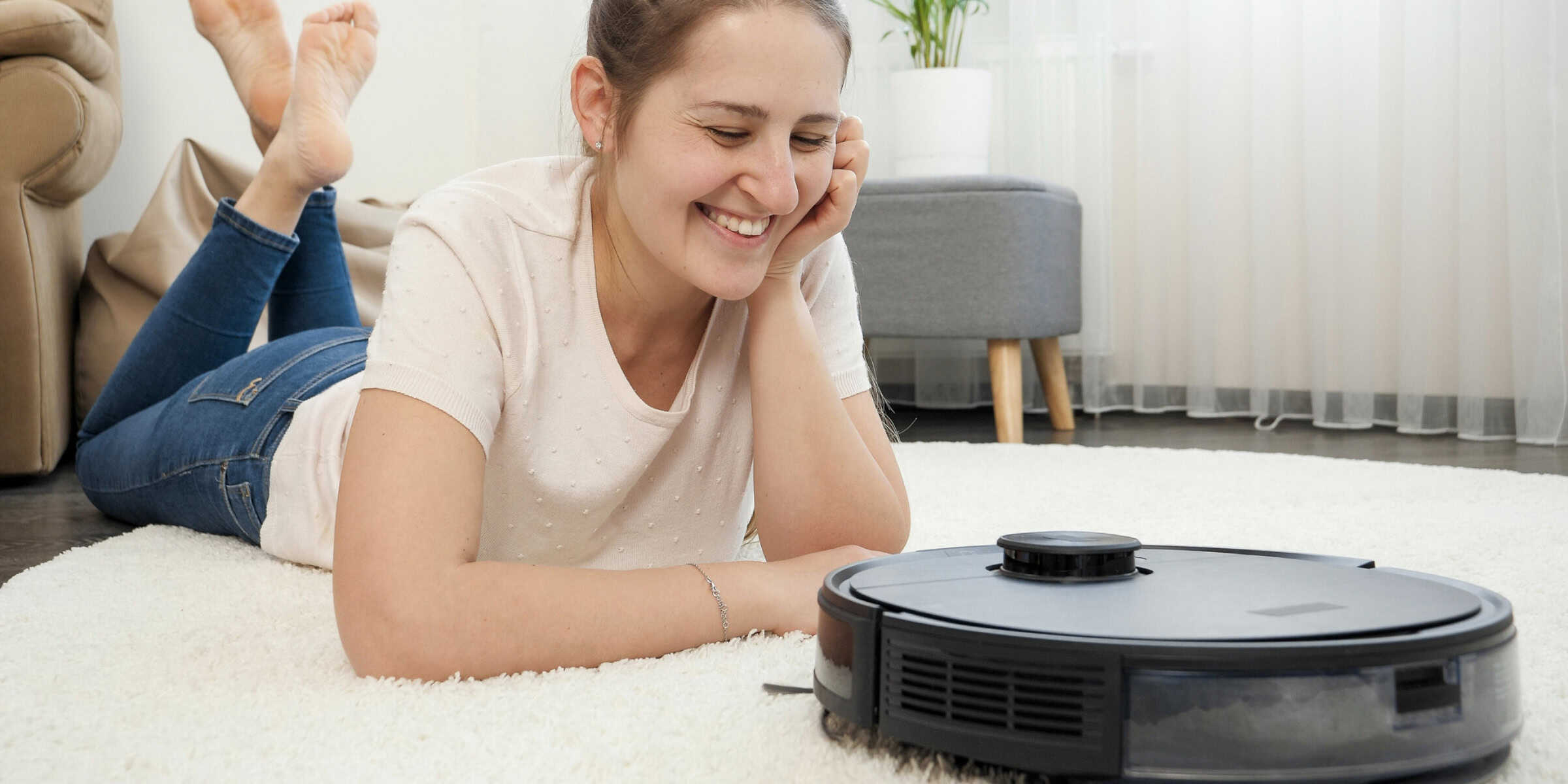 Woman smiling at robot vacuum