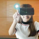 A young woman is holding a virtual reality headset.