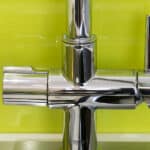 A close up of a kitchen sink with a chrome faucet.