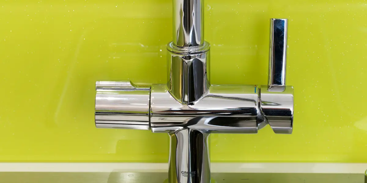 A close up of a kitchen sink with a chrome faucet.