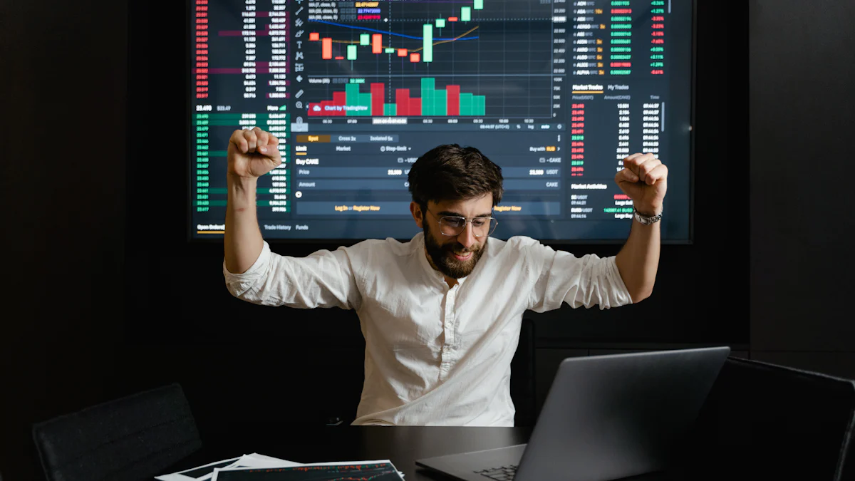A person in a white shirt raises their fists in celebration in front of a laptop, with a large screen showing financial graphs and charts in the background.
