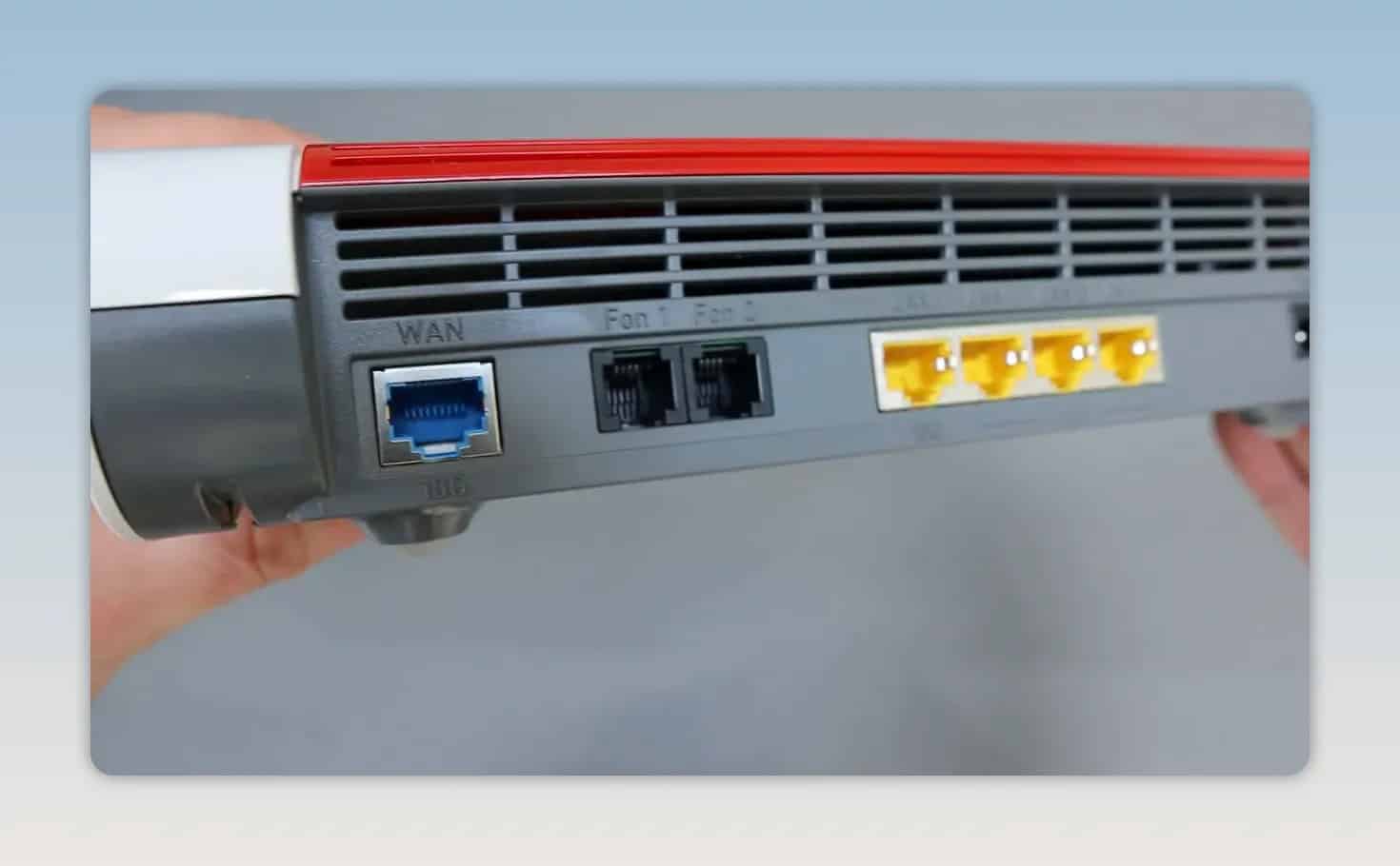 Rear panel of FRITZ!Box 4690 showing blue and black network ports and three yellow LAN ports