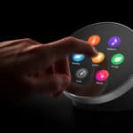 A hand selects the “Lights” icon on a circular smart home touchscreen displaying various control options against a black background.